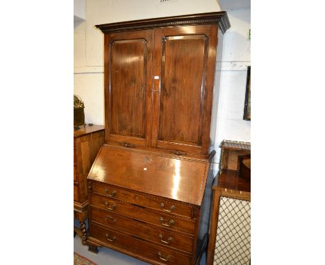18th Century mahogany bureau bookcase, the dentil and moulded cornice above two arched panel doors enclosing shelves above tw