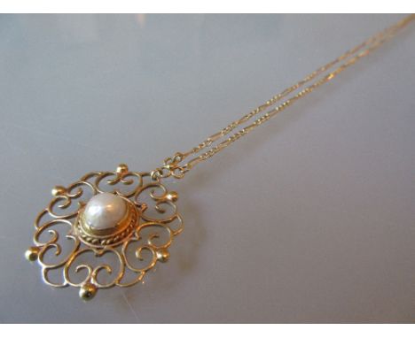 Circular gold pendant set baroque pearl on a gold chain