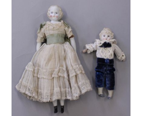 Two Parian dolls with blonde molded hair, larger doll with bisque forearms and lower legs with painted pink bows and black bo