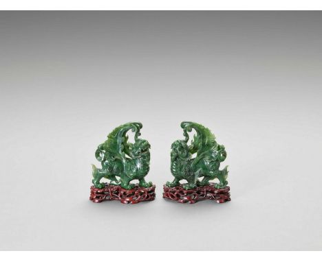   A PAIR OF SPINACH-GREEN JADE FIGURES OF QILIN, LATE QING TO REPUBLIC  China, late 19th century to early 20th century. The b