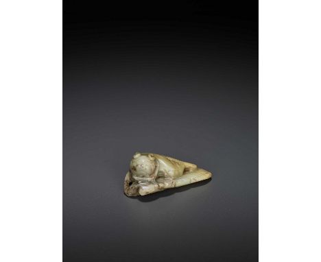   A JADE ‘CAT’ PENDANT, MING  China, 1368-1644. The cat depicted recumbent with its head raised and tilted to the side, the s