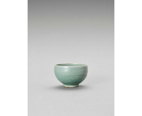  A CELADON-GLAZED CERAMIC BOWL  China, Song dynasty or later. The earthy bowl with engraved designs on the exterior, all ben