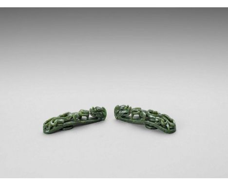   TWO SPINACH GREEN JADE ‘DRAGON’ BELT HOOKS, LATE QING  China, late Qing dynasty (1644-1912). The top is carved in openwork 