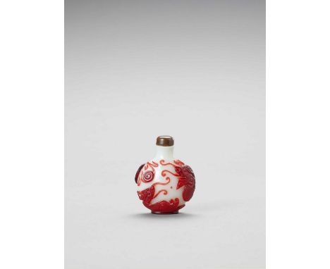   A RUBY-RED OVERLAY GLASS 'DRAGON' SNUFF BOTTLE  China, c. 1900. The ruby-red thick glass layer carved with a pair of dragon