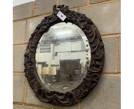 An 18th century style carved wood oval wall mirror, width 57cm, height 67cm