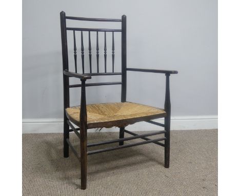 In the manner of William Morris, an antique ebonised Sussex Chair,&nbsp;with turned bobbin back and rush seat, W 52 cm x H 85