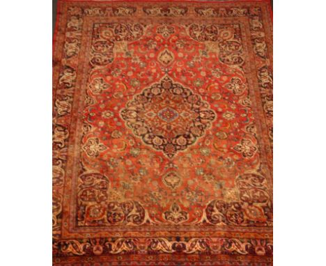 Large Persian red ground rug carpet, large central rosette medallion, scrolling interlaced floral field, enclosed by multiple