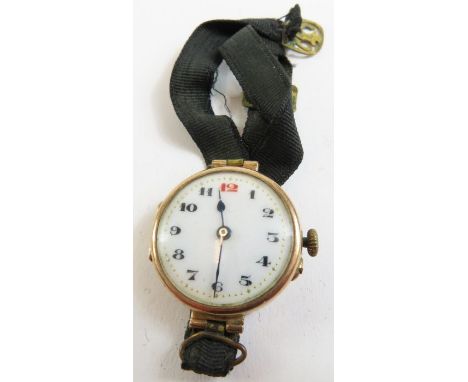 A 9 carat gold trench style wrist watch, the white enamel dial with black Arabic numerals (red 12) and blue steeled hands, on