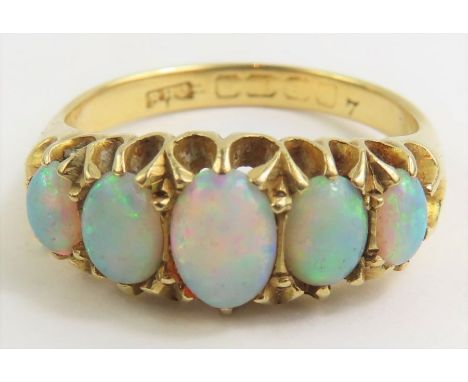 A late 19th/early 20th century opal five stone ring, claw set with graduated oval cabochon cut stones, the centre stone appro