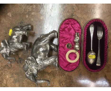 Cased Victorian silver fork and spoon christening set and pair of white metal clad elephants, plated baby rattle