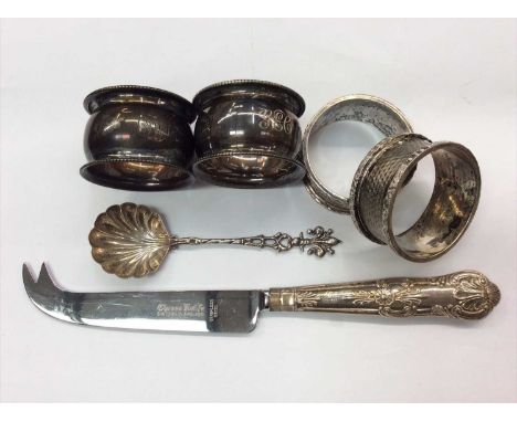 Four silver napkin rings, silver handled cheese knife and a white metal caddy spoon