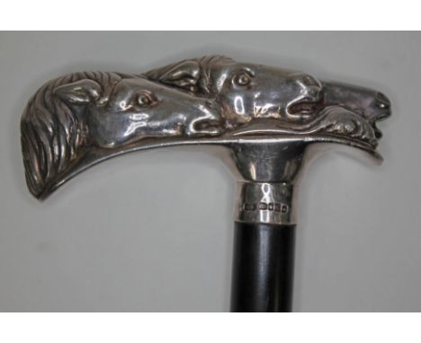 A modern silver handled walking stick, the handle formed from horses heads, ebony cane, length 93cm, sponsor's initials KG, S