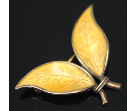 A Norwegian silver and yellow enamel leaf brooch designed by Willy Winnaess for David Andersen, length 39mm.  Condition - tar