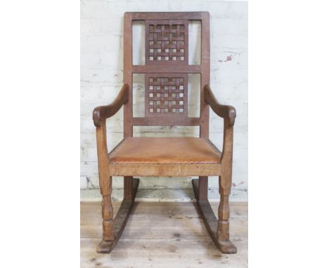 A Robert "Mouseman" Thompson of Kilburn oak rocking chair with lattice back, studded leather seat and carved mouse signature 