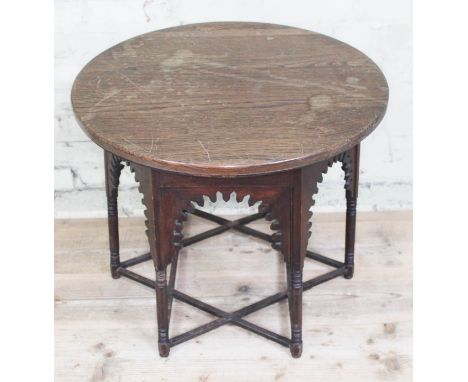 A Moorish oak occasional table in the manner of Liberty &amp; Co, round top above hexagonal section base with dentilated frie