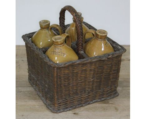 A set of four Victorian stoneware spirit bottles stamped SCOTCH WHISKEY, GIN, IRISH WHISKEY and BRANDY, within wicker holder 