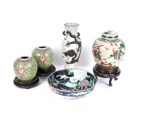 A collection of Oriental ceramics, comprising: a near pair of Chinese famille rose gingers jars on carved hardwood stands, 12
