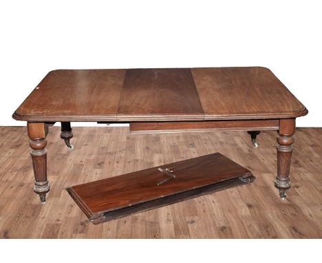 A substantial Victorian mahogany extending dining table, with moulded rounded rectangular top opening to receive three additi