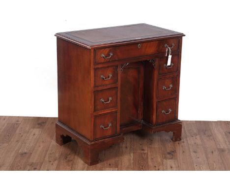 A substantial Georgian style mahogany kneehole desk, the moulded rectangular top with brown tooled leather writing surface ab