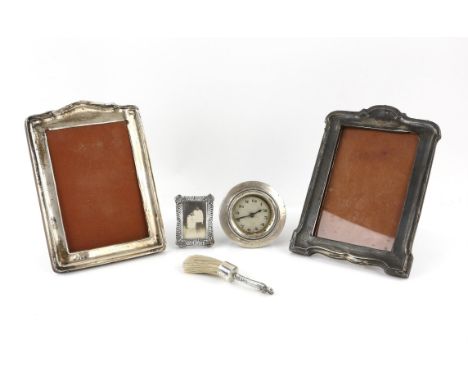 Three silver photo frames, the largest 20 cm high, a silver mounted desk brush and silver fronted desk clock (lacking body, (