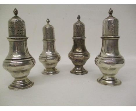 A matched set of four early 20th century silver pepper pots by Haseler Brothers, London 1910-1913, marks rubbed to one, on a 