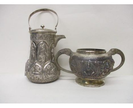 A late 19th/early 20th century Indian silver teapot and sugar basin, decorated with embossed and chased panels of figures, go