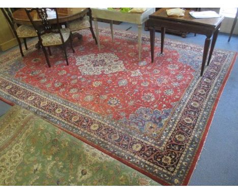 A Persian carpet with a central medallion, palmets and vines on a terracotta ground, 145" x 104" 