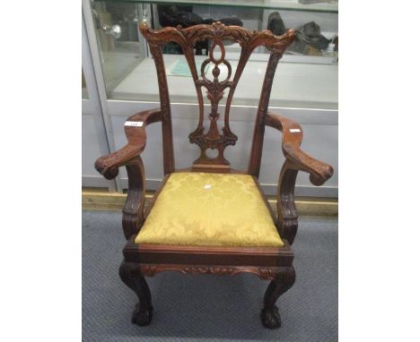 A reproduction mahogany Chippendale style child's chair having a craved top rail, pierced splat back and standing on two fron