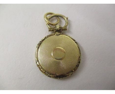 A 19th century gold coloured metal vinaigrette pendant of disc form with an engine turned, hinged front and back, enclosing a