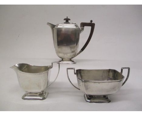 A 1930s silver three piece teaset by Henry Clifford Davies, Birmingham 1931 of square, tapered form with canted corners, on s