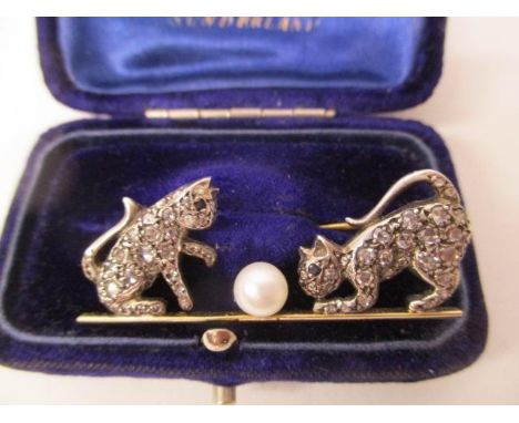 A gold and white coloured metal brooch fashioned as two kittens playing with a pearl, set with sapphire eyes and twenty eight