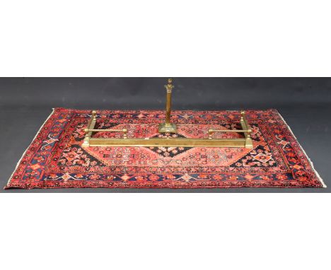 A Persian rug with all-over multi-coloured geometric design; together with a brass fender; &amp; a brass table lamp; with sha