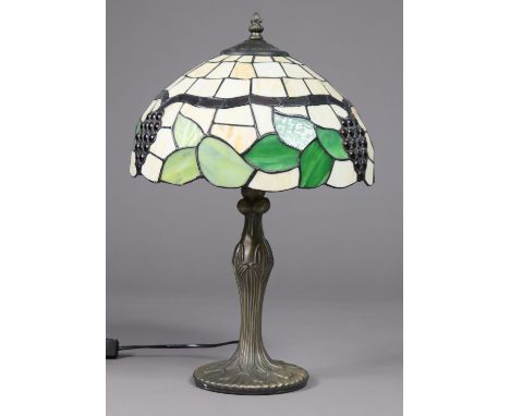 A modern Tiffany-style lamp, the leaded coloured glass domed shade decorated with bunches of grapes, on bronzed composition (