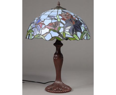 A modern Tiffany-style lamp, the leaded coloured glass domed shade decorated with hibiscus, on bronzed composition (resin) ba