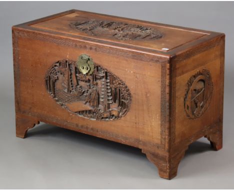 A mid-20th century southeast Asian camphor wood trunk with carved decoration to the hinged lift-lid, front, back &amp; sides,