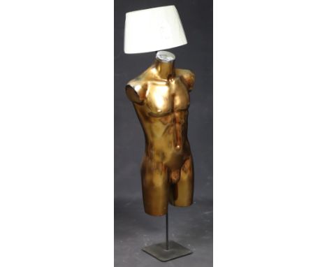 A gilt composition novelty male torso standard lamp on a black-finish metal base, with shade, 145cm high.