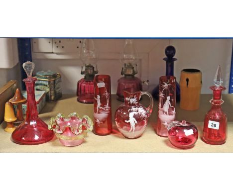 A pair of cranberry glass oil table lamps; seven items of cranberry &amp; ruby glassware; a blue glass decanter, etc.