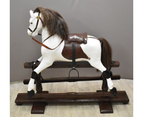 Carved wooded Rocking Horse with leather and metal fittings on trestle base, length 117cm