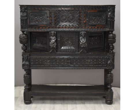 Elizabeth I / Tudor jointed oak and parquetry inlaid figurally decorated canted court cupboard, the single plank top raised a