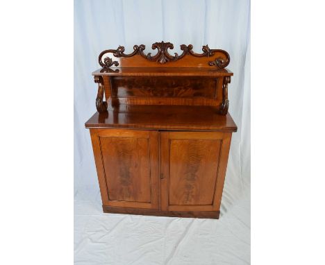 Victorian mahogany chiffonier with carved floral pediment over a small shelf supported with S-shaped supports over a base wit