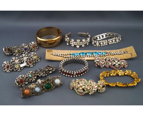 A selection of jewellery to include a rolled gold engraved bangle and eleven paste set costume bracelets. Approximate gross w