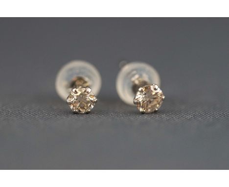 A white metal pair of single stone diamond stud earrings. Stated weight of 0.15ct each. Post and butterfly fittings. Post sta