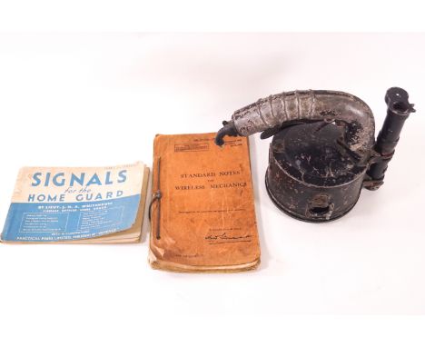 A WWII signal lamp with a 1942 ediion of Stand Notes for Wireless Mechanic and Signals for the Home Guard