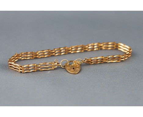 A yellow gold three bar gate bracelet, padlock and safety chain fitting. Hallmarked 9ct gold, Birmingham, 1990. 3.6 grams