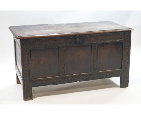 A 17th century oak coffer with interior candle box, iron lock and butterfly hinges to lid, the three panel front with carved 