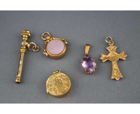 A selection of five gold charms to include a citrine baton, a gold locket, an agate/carnelian spinner, a gold cross and an am