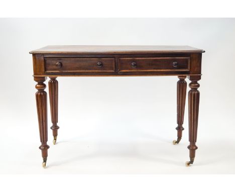 A 19th century mahogany two drawer side table on gadrooned legs and ceramic casters, 73cm high x 104cm wide x 52.5cm deep