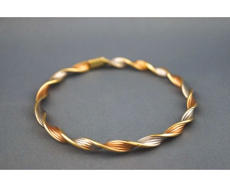 A 9ct tri coloured gold twisted gold bangle, 7cm diameter, applied pad marked "9KT" "Italy", London import marks, 3.7 grams