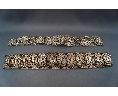 Two panel belts. comprising; a white metal example the rectangular panels depicting putti amidst flowers and leaf scrolls, ap
