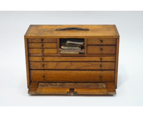 An oak engineer's cabinet, containing various tools, including lathe bits, callipers, dividers, micrometers.  Cabinet measure